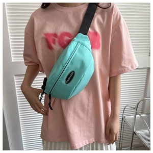 Detail of mint green crossbody bag with adjustable strap and Fashion patch on model