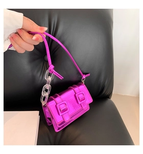 Detail of rose red metallic mini satchel with clear chain strap and glossy finish