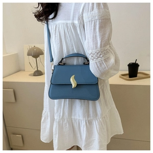 Sac bandoulière bleu en similicuir avec boucle dorée en forme de vague en décor intérieur