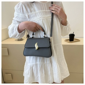 Détail d'un petit sac gris anthracite mat avec fermoir rotatif en métal doré