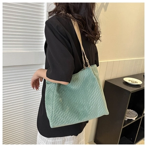 Detailed back view of a mint green checkered tote bag on model for size perspective
