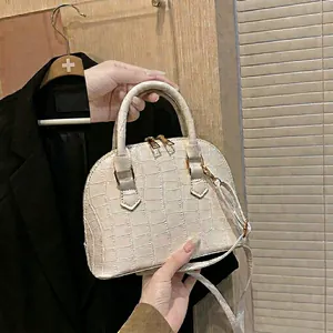 White crocodile pattern shell bag with golden hardware and adjustable strap