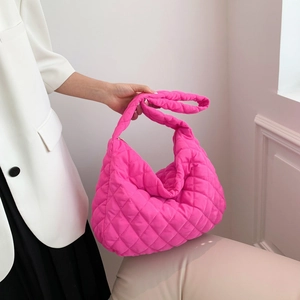 Quilted pink tote bag with large capacity and rhombic stitching in a minimalist setting