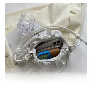 Top view of white pleated canvas bag interior showing capacity for smartphones and wallet
