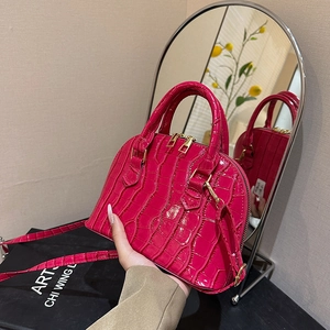 Pink faux leather shell bag with crocodile texture, featuring dual handles and gold hardware