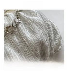 Detail of white pleated silk fabric with silver petal-shaped metal chain accessory