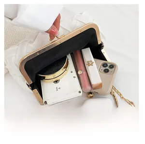 Interior view of white woven shell bag showing capacity for phone and cosmetics