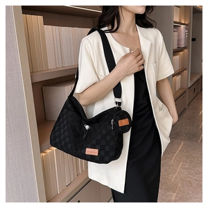 Detail of checkered canvas tote bag with a small round pouch and fashion leather label