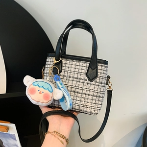 Secchiello chic in tweed bianco e nero con ciondolo blu e tracolla regolabile