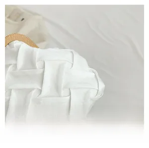 Detail of white woven fabric texture with vintage gold embossed metal clasp on top