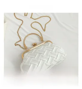 Detail of white woven satin evening bag with gold clasp and chain strap texture
