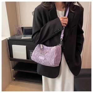 Détail du sac à bandoulière plissé violet avec chaînes de perles et étiquette mode