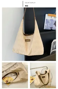 Close-up of beige quilted canvas tote bag with brown leather handles and brand patch