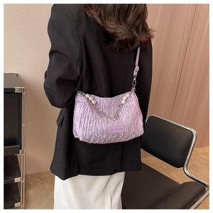Détail du sac bandoulière plissé violet avec grande bandoulière perle et chaîne en métal