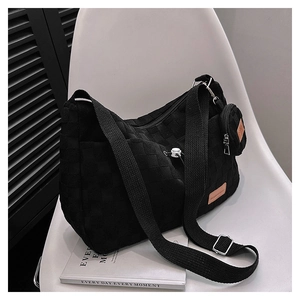 Detail of black woven checkerboard tote bag with adjustable strap and small round pouch
