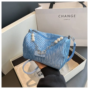 Détail du sac plissé bleu clair avec bandoulière en perles et fleurs argentées