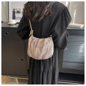 Close-up of pleated pink cloud bag with silver chain strap on a female model