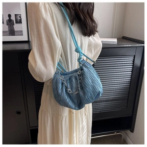 Detail of light blue pleated cloud bag with silver floral metal chain and silk texture
