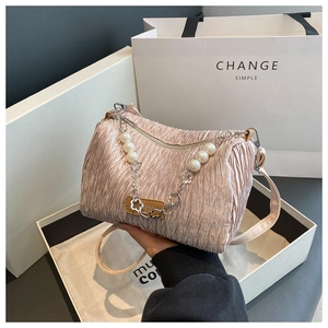 Détail du sac à main plissé rose en soie avec chaîne décorative en perles et fleurs