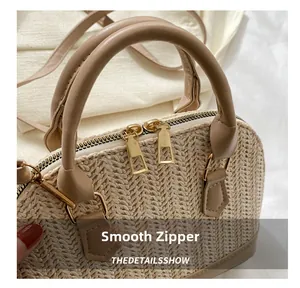 Detail des glatten Metallreißverschlusses und Ledergriffs an der beigen Web-Tasche