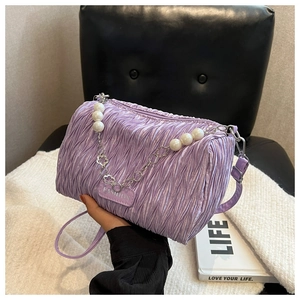Détail d'un sac à main plissé violet avec perles et bandoulière en chaîne