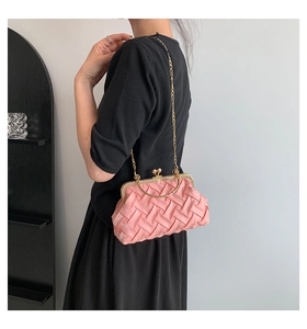 Detail of pink woven satin handbag featuring golden handle and vintage metal clasp