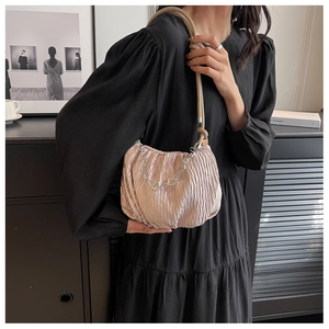 Detail of light pink pleated shoulder bag with floral silver chain and rope strap