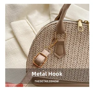 Nahaufnahme der goldenen Haken und des Lederriemens an der gewebten Stroh-Muscheltasche