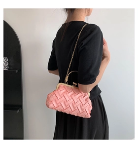 Detail of pink woven satin shell bag with gold metal frame and chain shoulder strap