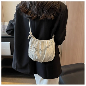 Detail of white pleated shoulder bag with floral silver chain and cord strap
