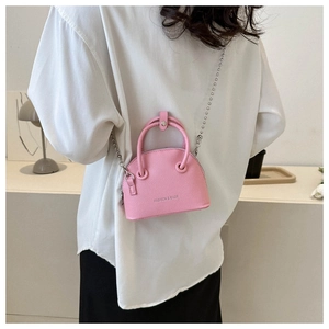 Close-up of pink shell bag with litchi texture leather and silver bead chain strap