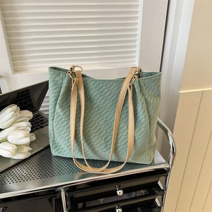 Vintage green quilted tote bag with brown handles on office cart with tulips