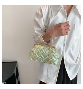 Macro detail of mint green woven crossbody bag featuring vintage gold clasp and satin finish