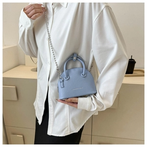 Detail of light blue shell crossbody bag with litchi grain texture and silver bead chain