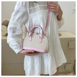 Detailansicht einer gewebten Muscheltasche aus rosa Leder und Stroh für den Sommer