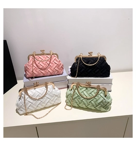Detailed view of woven satin evening bags with golden metal ball clasp and chain