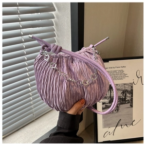 Close-up of light purple pleated cloud bag featuring silver floral chain detail