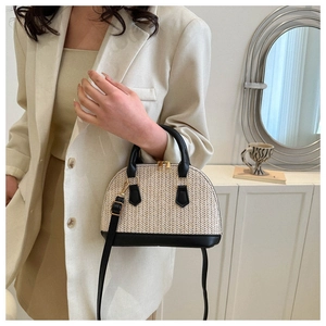 Detail der handgewebten beige Muschel-Tasche mit schwarzem Leder und Goldreißverschlüssen