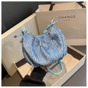 Detail of sky blue pleated cloud bag with silver clover chain and soft satin texture