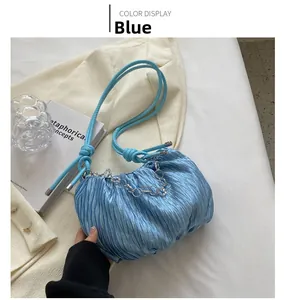 Detail of blue ruched cloud bag with pearlescent finish and silver chain strap