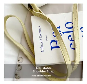 Close-up of adjustable beige shoulder strap with gold buckle and fine stitching
