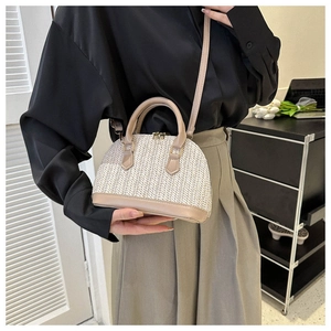Detail der cremefarbenen gewebten Muscheltasche mit khakifarbenen Ledergriffen und Golddekor