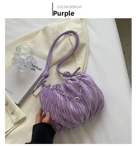Close-up of purple pleated canvas bag with stylish drawstring handle and silver chain