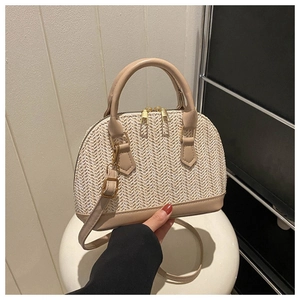 Detailansicht der Strohtasche in Muschelform mit Ledergriffen und Reißverschlüssen