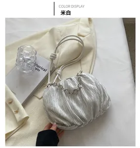 Detail view of off-white pleated cloud bag with knotted rope strap and metal chain