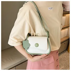 Detail of retro cream and green contrast shoulder bag with flower charm and metal buckle