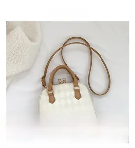 Detail of white quilted texture and gold zipper hardware on a stylish handbag