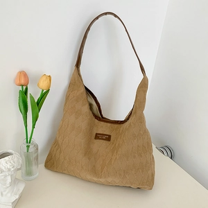 Minimalist khaki quilted tote bag with brown leather straps and spacious interior