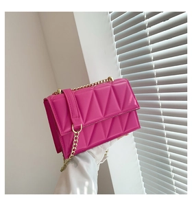Detailed close-up of rose pink quilted leather chain bag with golden metal hardware