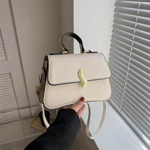 Sac bandoulière minimaliste abricot avec boucle dorée ondulée et bordures noires